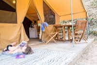 Camping Vieux Vallon - ein Campinggast liest in der Nähe eines Zeltes 