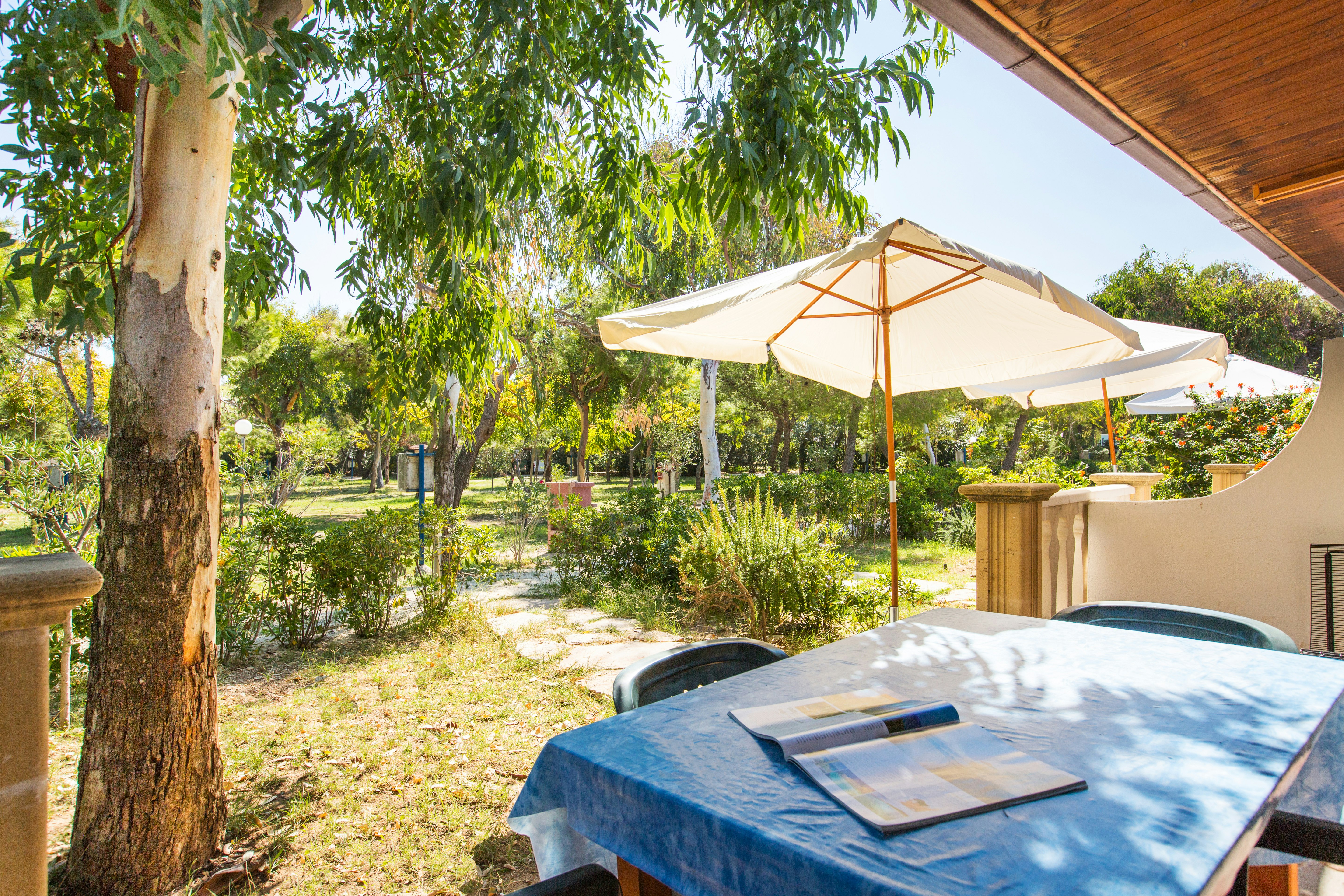 Camping Village Baia Falcone  - Blick von der Veranda eines Mobilheims ins Grüne auf dem Campingplatz