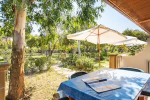 Camping Village Baia Falcone - Blick von der Veranda eines Mobilheims ins Grüne auf dem Campingplatz