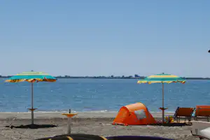 Camping Village Belvedere Pineta - Strand am Campingplatz mit Liegestühlen und Sonnenschirmen