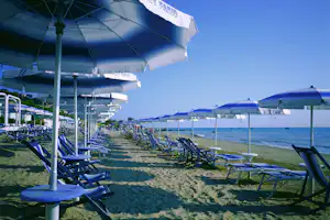 Camping Village Don Diego - Strand vom Campingplatz mit Sonnenschirmen und Liegestühlen