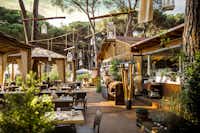 Camping Village Fabulous  -  Restaurant vom Campingplatz mit Terrasse zwischen Bäumen
