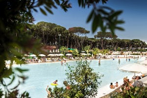 Camping Village Fabulous - Blick auf den Pool vom Campingplatz mit Sonnenschirmen und Liegestühlen, Mobilheime im Hintergrund