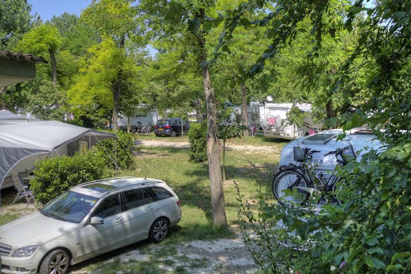 Camping Village Flaminio  -  Wohnwagen- und Zeltstellplatz zwischen Bäumen auf dem Campingplatz
