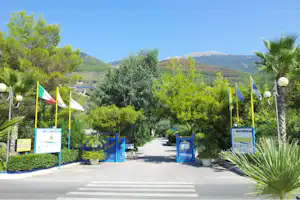 Camping Village International - Einfahrt vom Campingplatz mit Blick auf die Berge von Italien