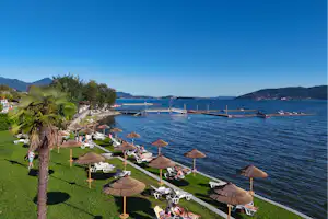 Camping Village Isolino - Badestrand mit Liegewiese und Liegestühlen auf dem Campingplatz
