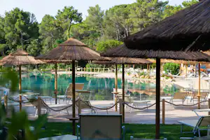 Camping Village Le Esperidi - Poolbereich vom Campingplatz mit Liegestühlen und Sonnenschirmen