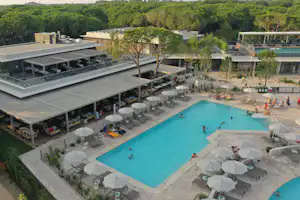 Camping Village Mediterraneo - Pool im Freien mit Liegestühlen und Sonnenschirmen