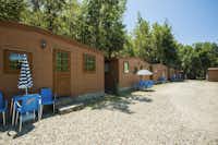 Camping Village Mugello Verde  -  Mobilheime vom Campingplatz mit Esstischen und Sonnenschirmen
