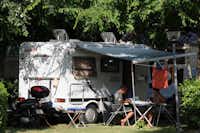 Camping Villaggio Adria - Camper sitzen vor dem Wohnmobil im Schatten der Bäume