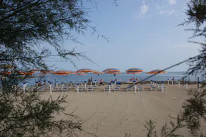 Camping Villaggio Pineta al Mare - Strand mit Sonnenschirmen und Liegestühlen am Campingplatz