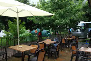Camping Viu - Veranda mit Sitzgelegenheiten und Sonnenschirm