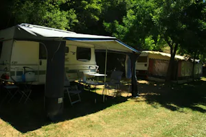 Camping Viu - Wohnwagen mit Vorzelt unter Bäumen