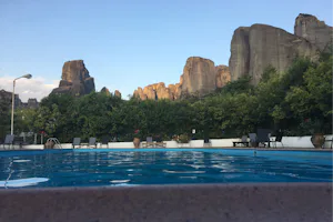 Camping Vrachos Kastráki - Blick auf den Pool vom Campingplatz mit Sitzmöglichkeiten, Berge im Hintergrund