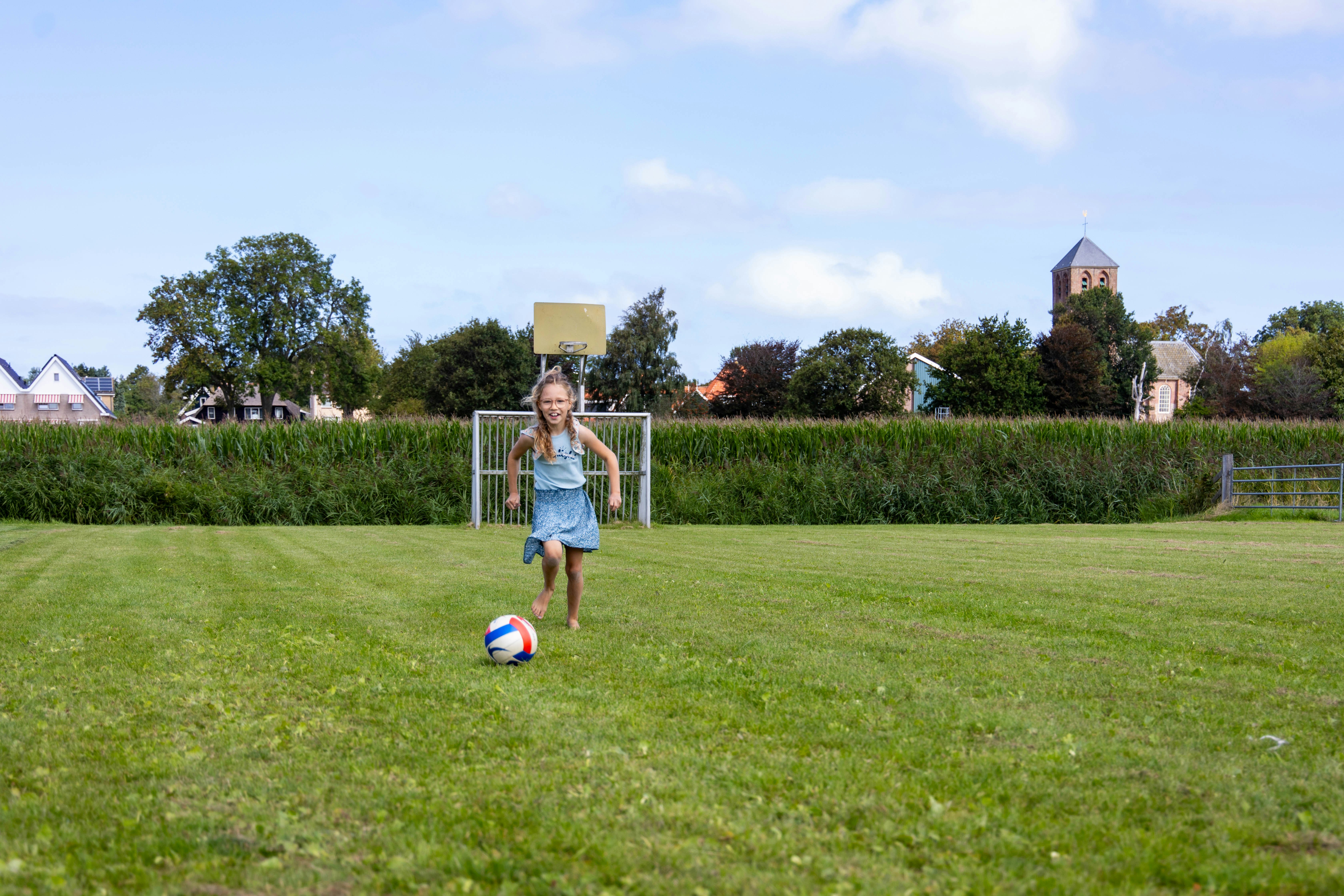 Camping Waddenzee - Kind spielt Fußball auf der Wiese