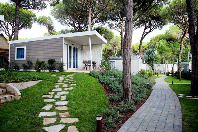 Camping Waikiki   -  Mobilheime zwischen Bäumen auf dem Campingplatz