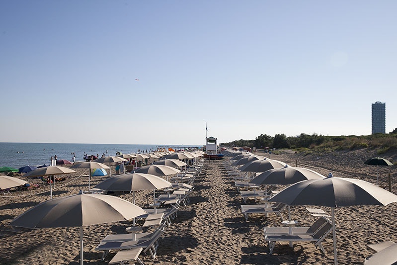 Camping Waikiki  -  Strand mit Sonnenschirmen und Liegestühlen am Campingplatz