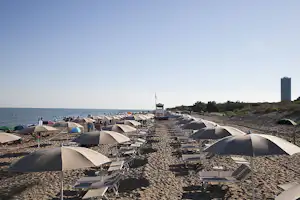 Camping Waikiki - Strand mit Sonnenschirmen und Liegestühlen am Campingplatz