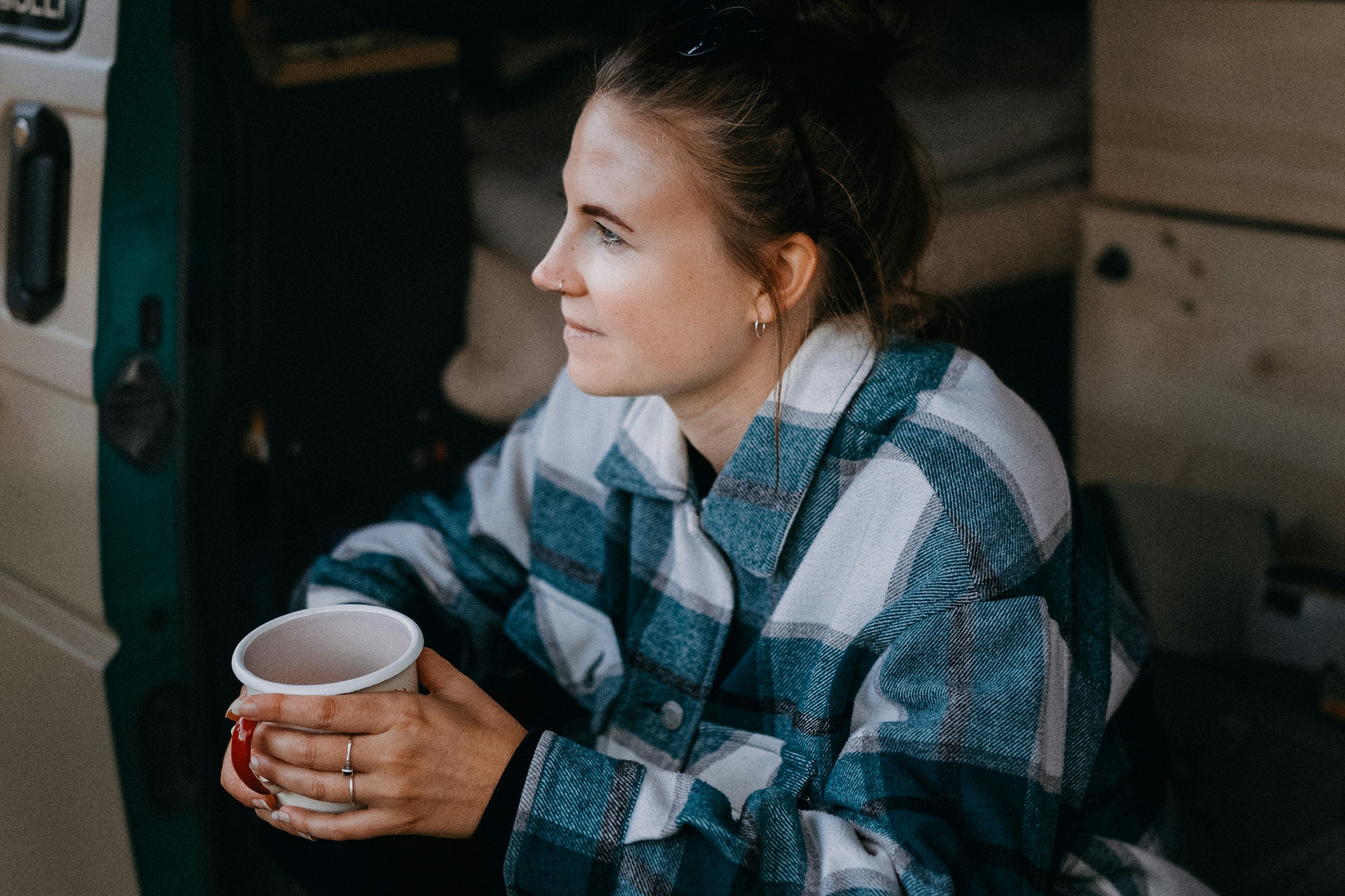 Wildwood Camping Harz  Camping Waldweben - Camperin sitzt in ihrem Van und genießt einen Kaffee