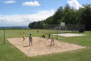 Camping Walkyrien - Volleyball spielende Camper auf Volleyballfeld vom Campingplatz, die Ostsee im Hintergrund