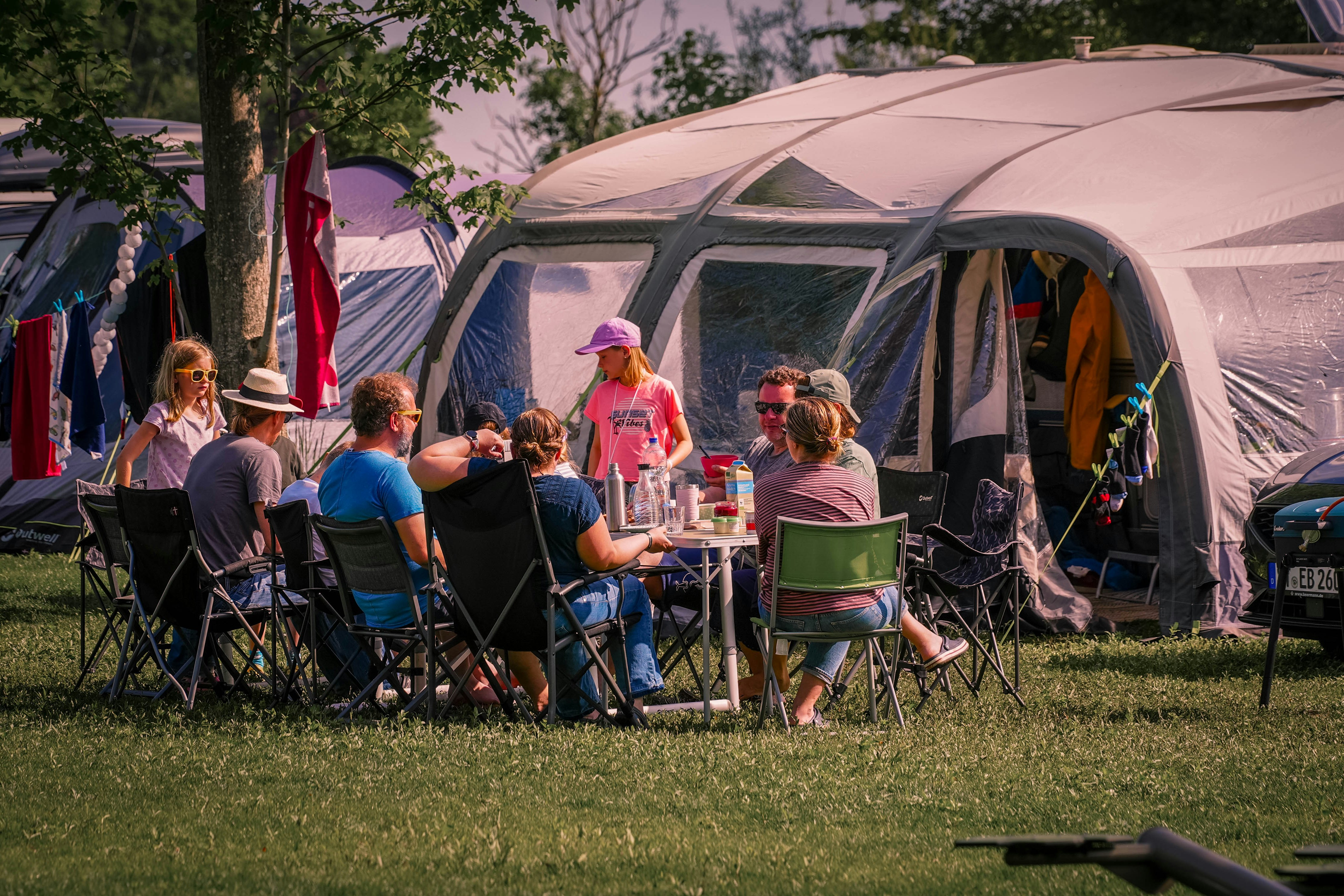 Camping Wedderbergen - Familien sitzen auf der Standplatzwiese beisammen