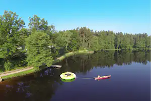 Camping Weichselbrunn - Gäste beim Kanufahren und Trampolinspringen im See vor dem Campingplatz