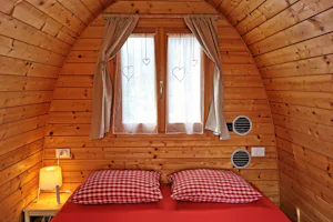 Camping Melezza - Doppelbett in einer Mietunterkunft auf dem Campingplatz