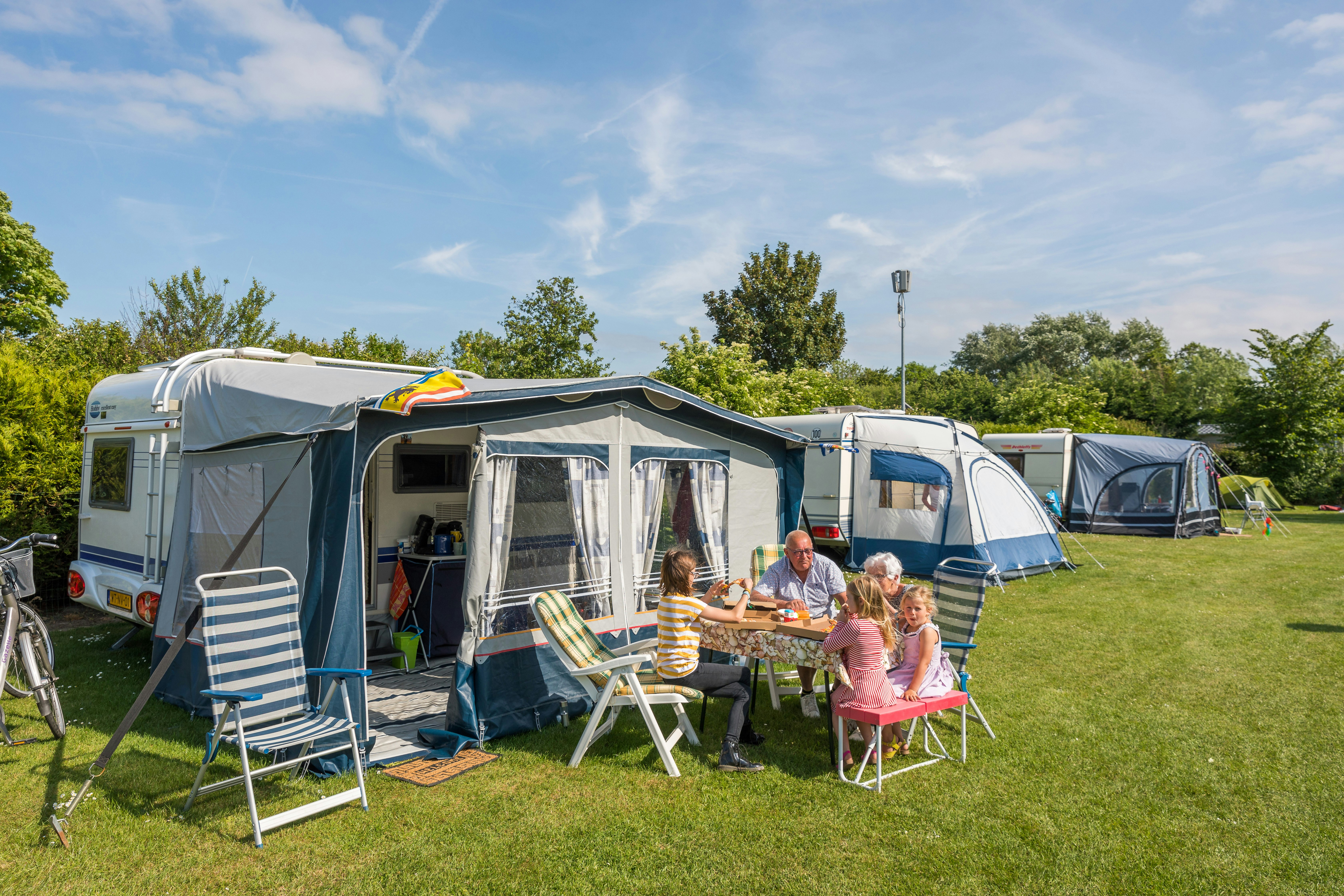 Ardoer Camping Zonneweelde - Familie entspannt auf ihrem Stellplatz
