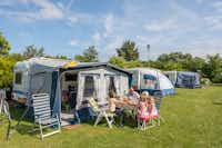 Ardoer Camping Zonneweelde - Familie entspannt auf ihrem Stellplatz