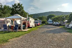 Camping Zora - Gehweg auf dem Wohnwagen- und Zeltstellplatz vom Campingplatz mit Blick auf grüne Hügel