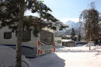 Camping zur Mühle - Schneebedeckte Wohnwagen in winterlicher Berglandschaft