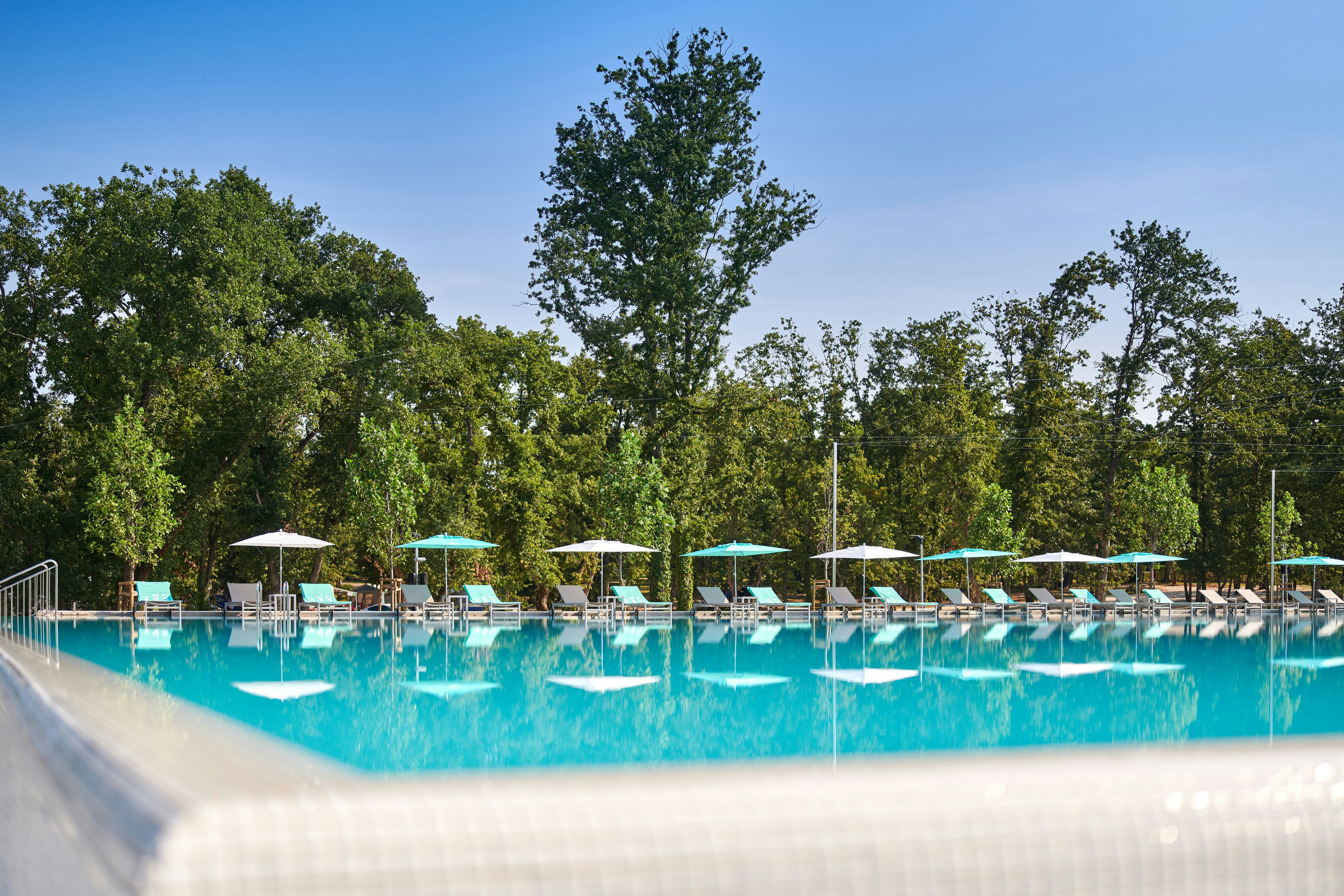 Camping Park Umag - Freibad mit Liegestühlen und Sonnenschirmen auf dem Campingplatz