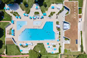 Camping Stella Maris - Pool im Freien mit Liegestühlen und Sonnenschirmen