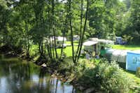 Campingpark Eifel - Wohnwagenstellplatz umringt von Wald auf dem Campingplatz