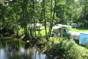 Campingpark Eifel - Wohnwagenstellplatz umringt von Wald auf dem Campingplatz