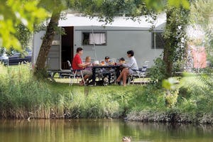 Campingpark Gitzenweiler Hof - Familie beim gemeinsamen Entspannen auf ihrem Stellplatz am Ufer