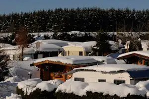Campingpark Hochsauerland - schneebedeckte Wohnmobile und Mobilheime auf dem Campingplatz im Winter