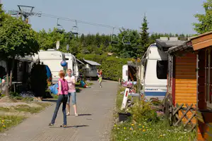 Campingpark Hochsauerland - spielende Kinder auf dem Wohnwagen- und Zeltstellplatz vom Campingplatz, Lift im Hintergrund