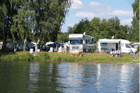 Campingpark Kamerun - Gäste am Wasser vor den Wohnmobilstellplätzen im Grünen auf dem Campingplatz