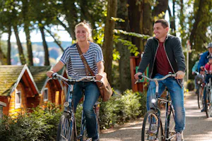 Campingpark Sanssouci - Fahrradfahrer auf dem Campingplatz mit Schlaffässern im Hintergrund
