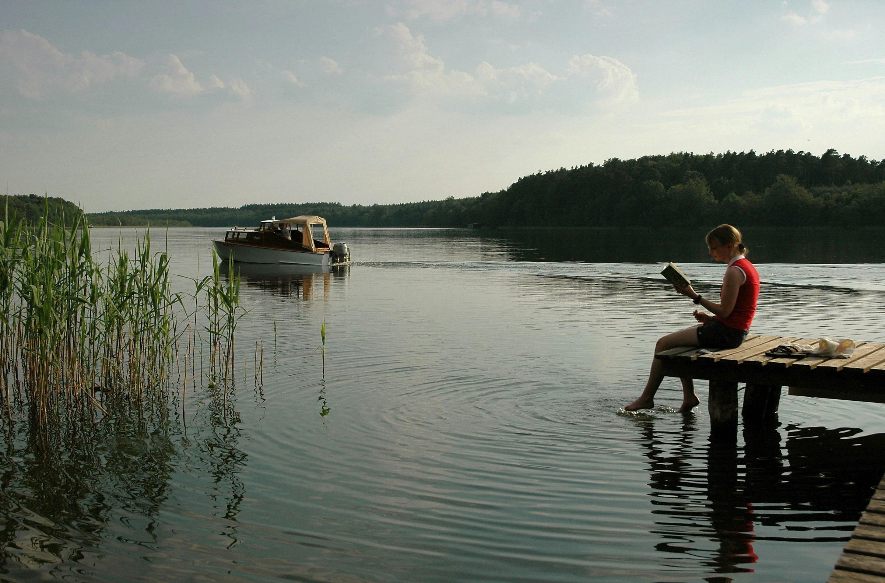 Campingplatz am Leppinsee - Camperin mit Buch auf Steg