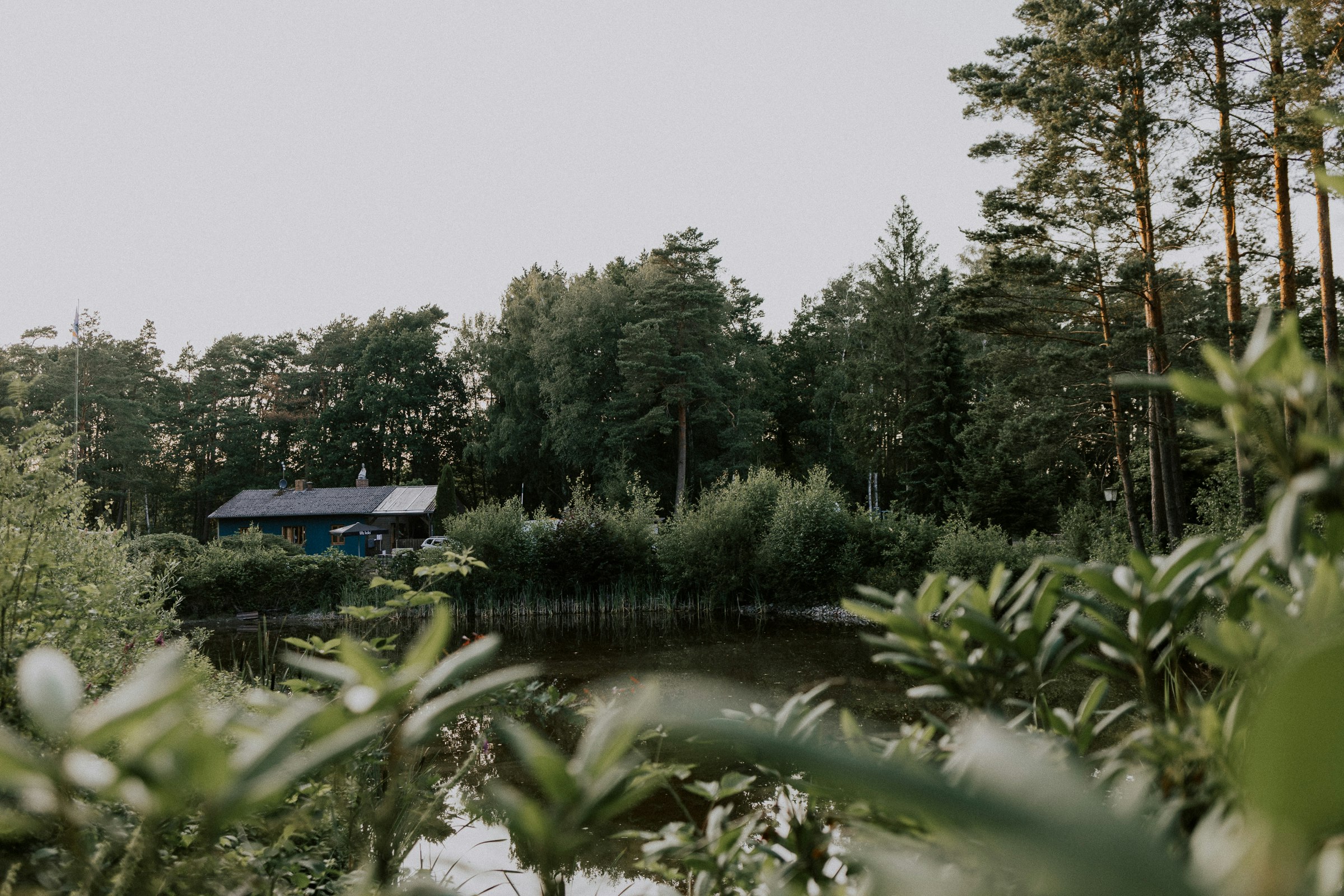 Wildwood Camping Lüneburger Heide - Blick über das Wasser zum Clubhouse am anderen Ufer im Grünen
