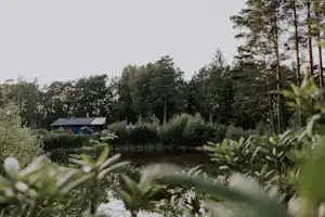 Wildwood Camping Lüneburger Heide - Blick über das Wasser zum Clubhouse am anderen Ufer im Grünen
