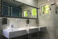 Campingplatz Berolina - Sanitärgebäude mit Waschbecken, Spiegel, Toiletten und Duschen