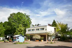 Campingplatz der Stadt Köln - Eingangsgebäude mit Rezeption und Sanitäreinrichtungen sowie Kiosk auf dem Campingplatz