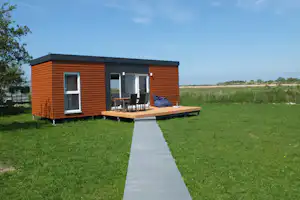 Campingplatz Flüggerteich - Mobilheim vom Campingplatz mit Sitzsack und Esstisch auf der Veranda