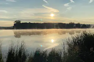 Naturcamp Kauerlach Campingplatz Kauerlacher Weiher - Blick auf den Campingplatz in der Morgensonne
