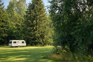 Campingplatz Maiburg - Caravan auf Wiese umgeben von Bäumen