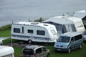 Campingplatz Möltenort - Wohnwagen auf dem Campingplatz mit dem Wasser der Ostsee im Hintergrund