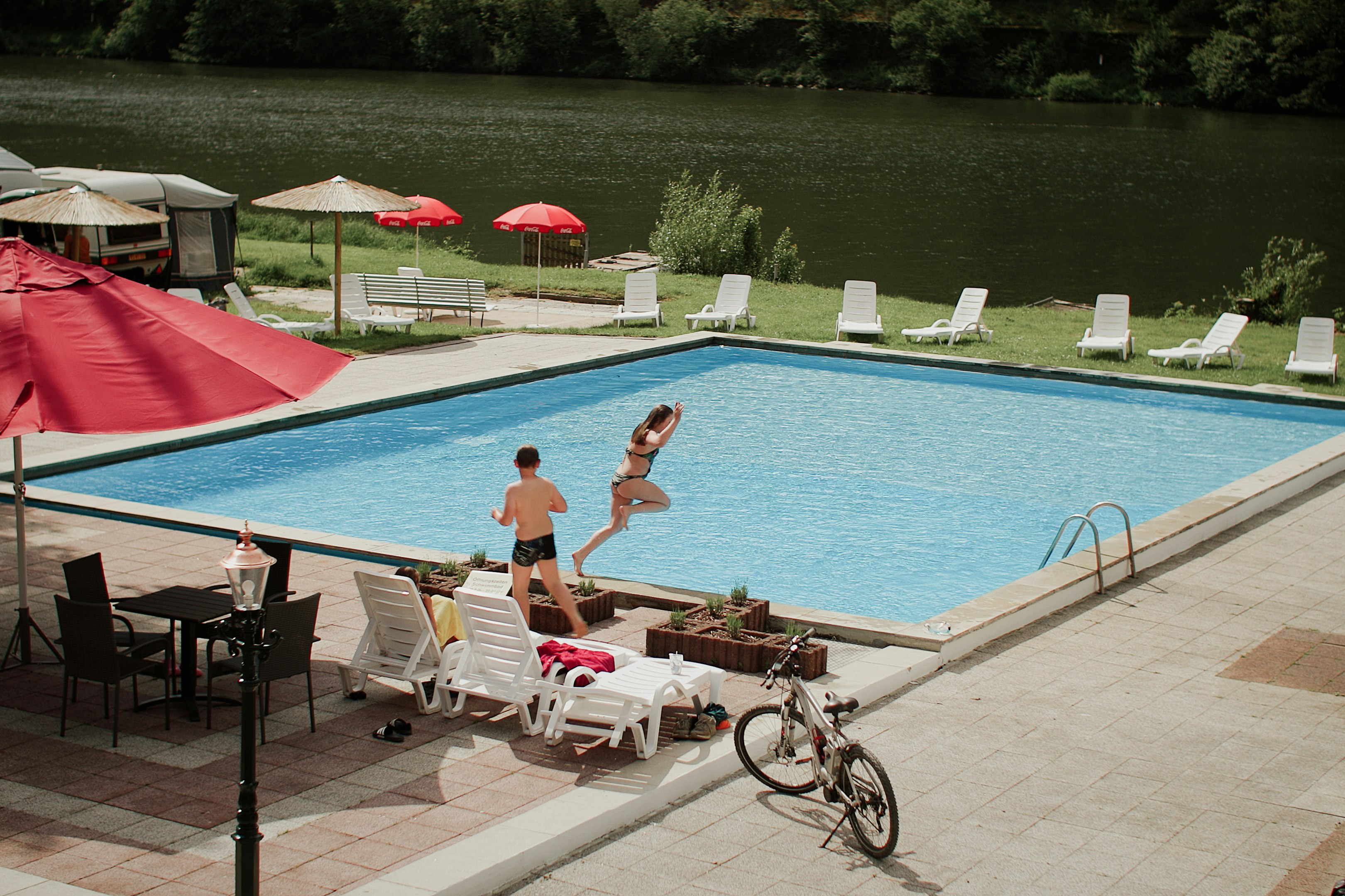 Campingplatz Mosel Wunder  - Pool im Freien mit Liegestühlen und Sonnenschirmen
